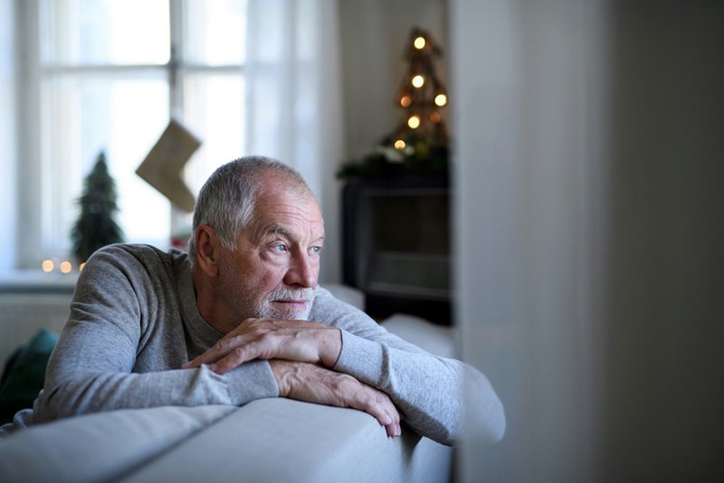 An older man sits alone in deep thought.