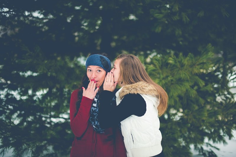 Two friends telling a secret to each other. Representation.