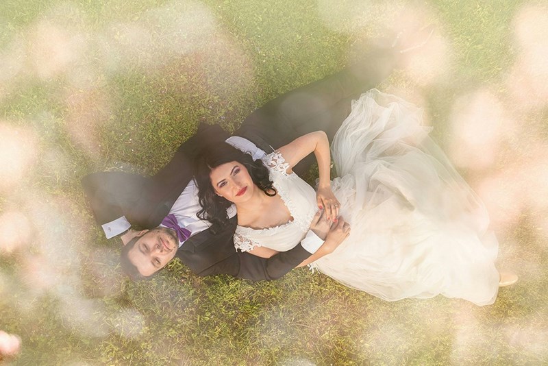 bride and groom sitting on grass