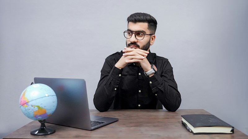 man sitting at a desk with a laptop