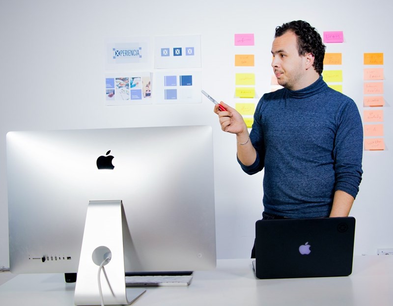 man pointing at post its on a wall