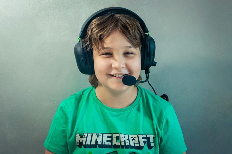 A 9-year-old boy plays Minecraft instead of participating in his parents' friends' birthday party, which he is perfectly content to do. 