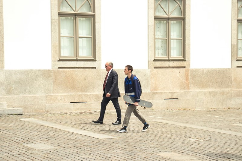 Two men of different generations walk beside each other outside