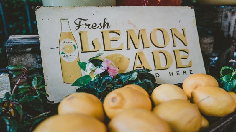 A lemonade stand sign with lemons.