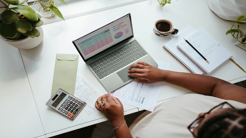 A person working in their computer at their desk.