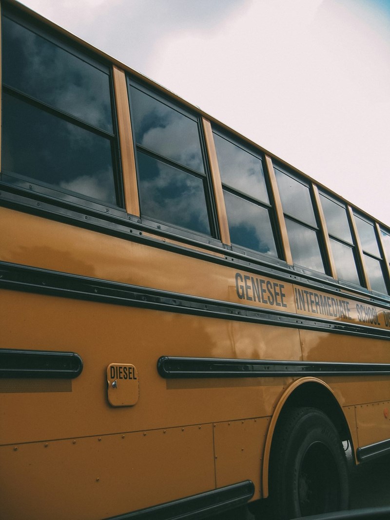 A yellow school bus representing summer campers traveling to a local swimming pool.