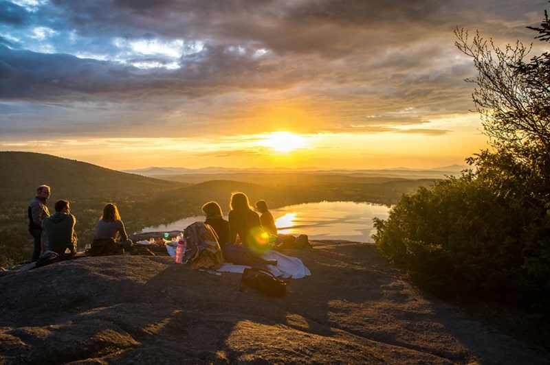 A group of friends in the sunset enjoying the view. Representation.