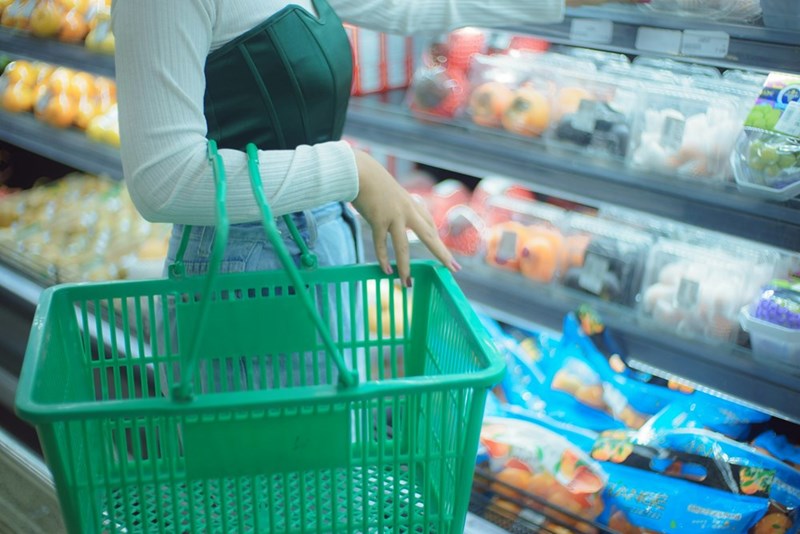 A woman buying food at a store. Scene shown is a visual representation.