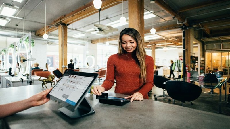 A woman working at the front counter of a store. Stock photography for depiction only.
