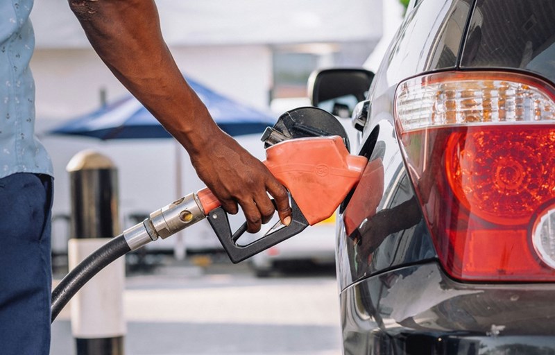 Son fills up his wife's gas tank because she doesn't know how to do it by herself. 