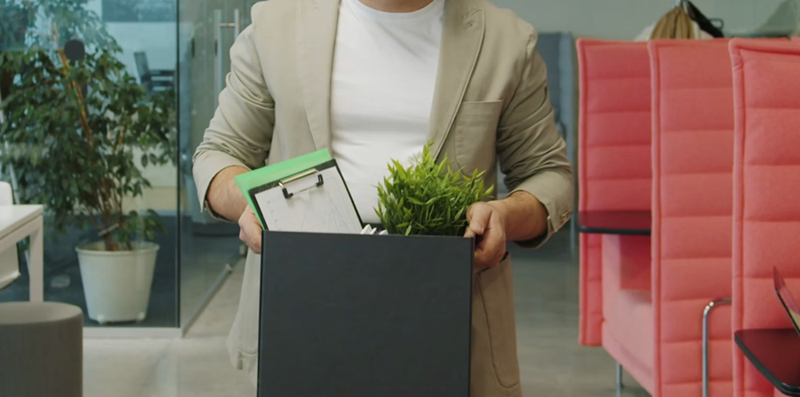 An employee carries out their belongings after being fired