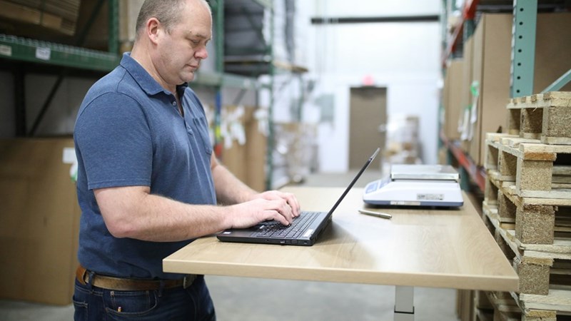 A warehouse employee works at a computer as inventory issues begin raising questions about missing equipment.