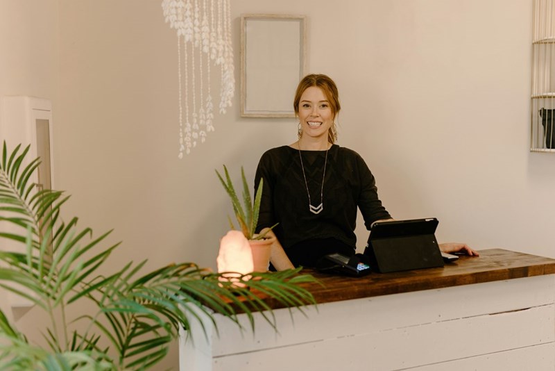 Esthetician working at the front desk of a med spa before the location shuts down and she is laid off.