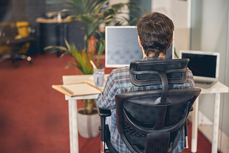 Employee sitting on an office chair at work.