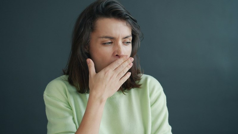 woman covering her mouth with hand