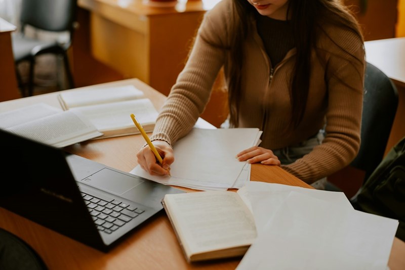 College student writing an essay.