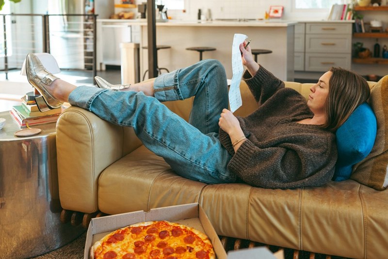 Woman lounging on a couch in her sister's apartment.