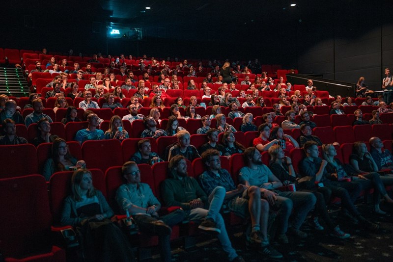 A crowd of people are watching the movie that the daughter in this story was forbidden from seeing. 