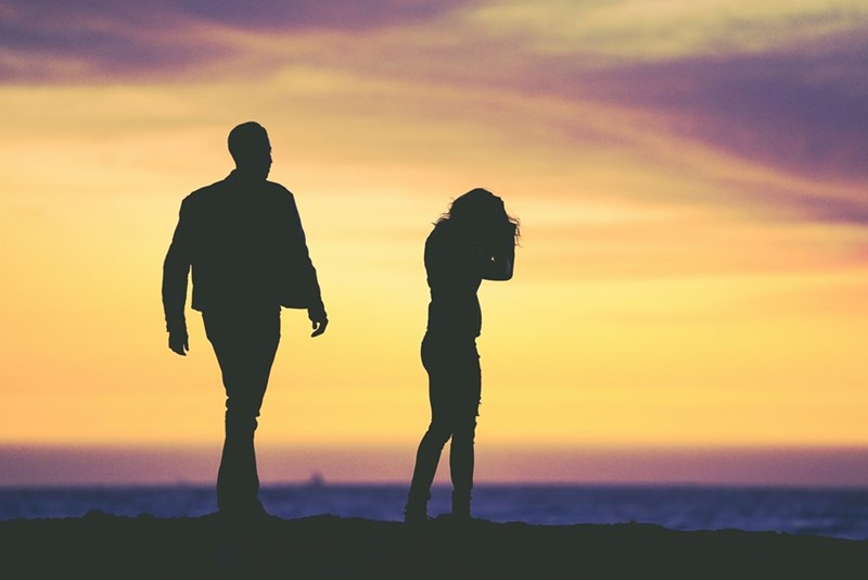 A couple of silhouettes discussing in the sunset. Actor performance of story events.