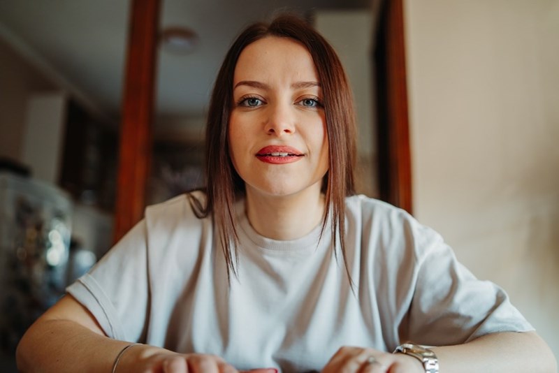 Woman sitting with a slightly surprised expersion like shes reading something she wasn't expecting.