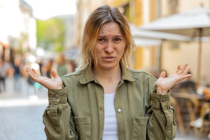 Woman shrugs with both hands up like she doesn't know what to do or say