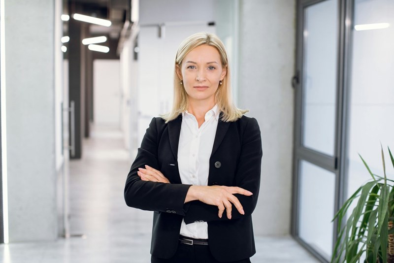 New manager standing in a modern office after being introduced to her team.