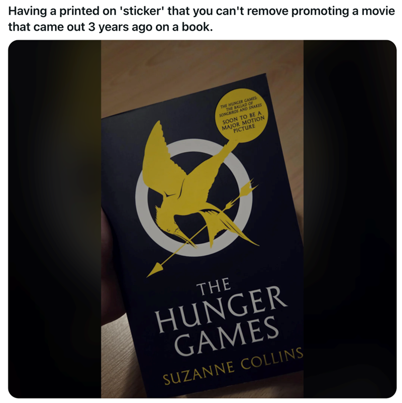 Having a printed on 'sticker' that you can't remove promoting a movie that came out 3 years ago on a book. JUNGER GAMES THE HALLAD OF THE SONGBIRDS SNAKES SOON TO BE A MAJOR MOTION PICTURE THE HUNGER GAMES SUZANNE COLLINS