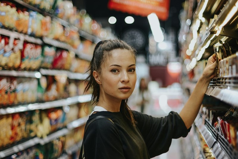 A woman buying food at a grocery store. Actor performance of story events.