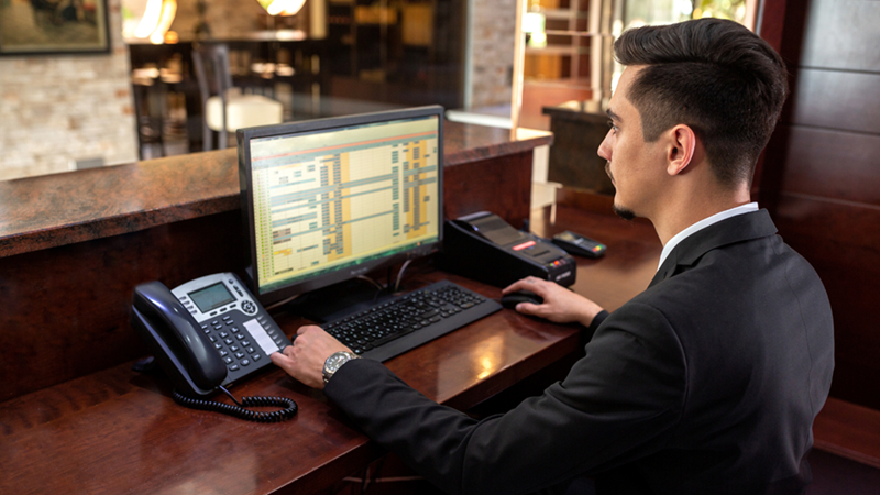 Hotel receptionist sitting behind a front desk