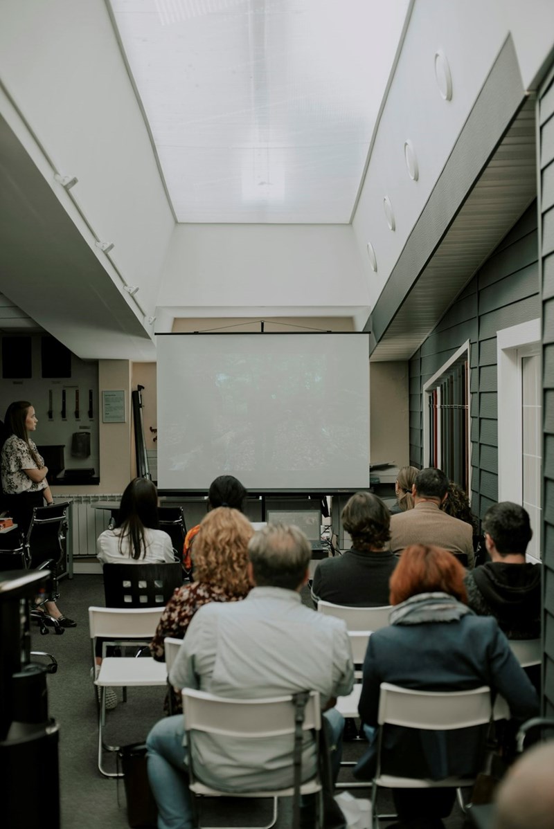Students sit together in a stark college classroom.