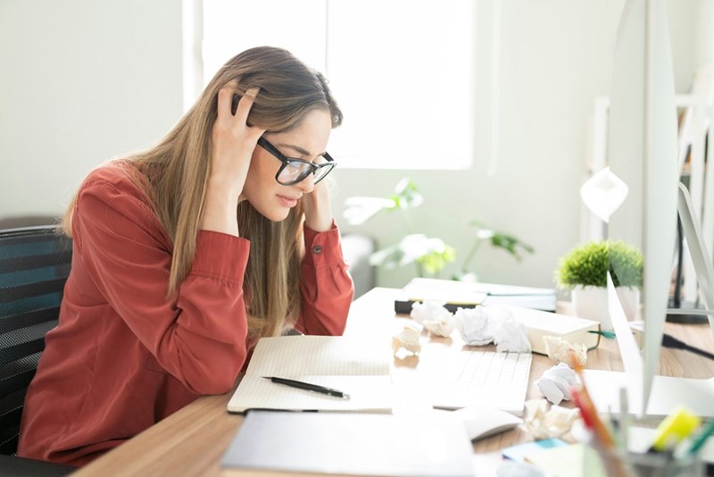 A young woman reacts to noise at her desk