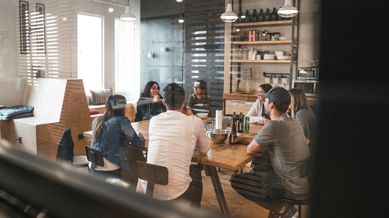 An office room full of employees having a meeting. Scene shown is a visual representation.
