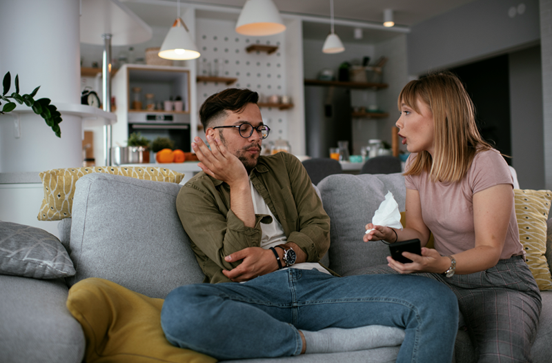 A boyfriend and girlfriend have an argument on the couch