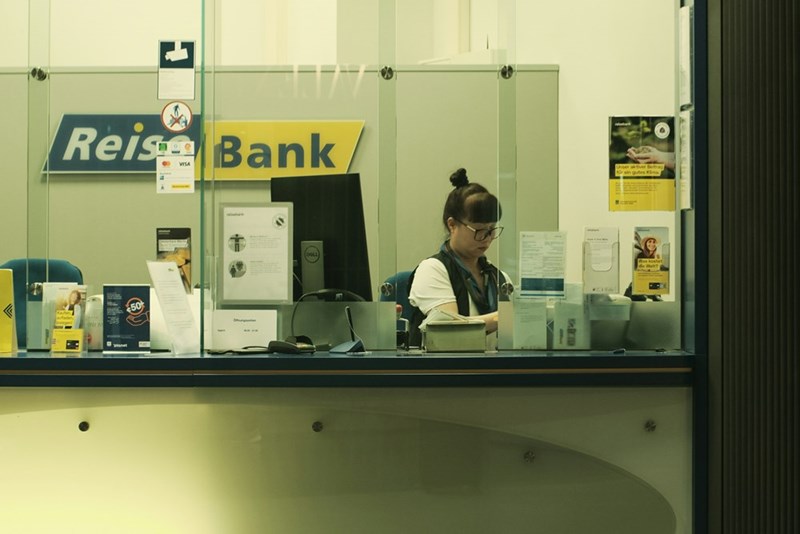 A woman sitting at a desk at the bank