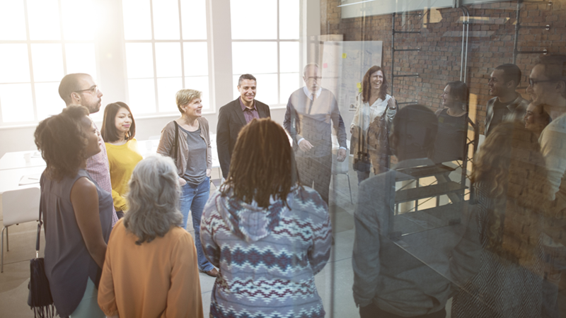 Office workers gathered together in a tight office space.