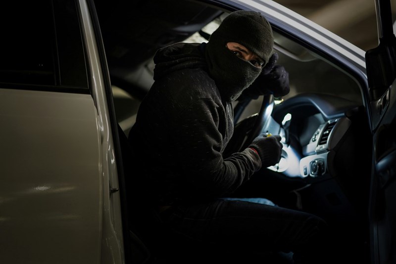 Robbers robbing the car in the parking lot at night