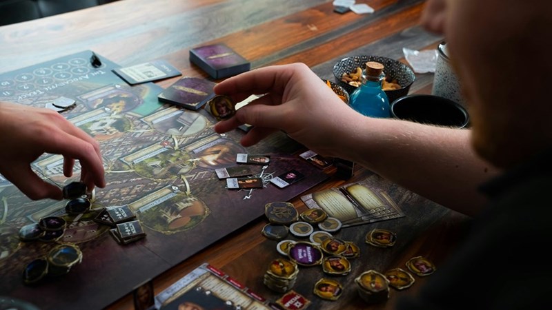 Two people playing a board game on a table.