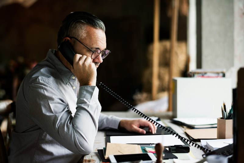 A boss talks on the phone at his desk