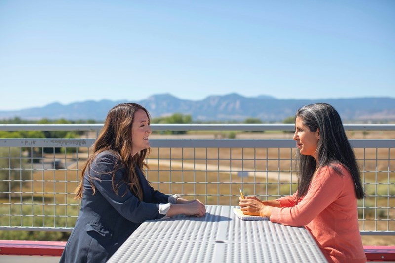 Two women have an argument on a bench outside