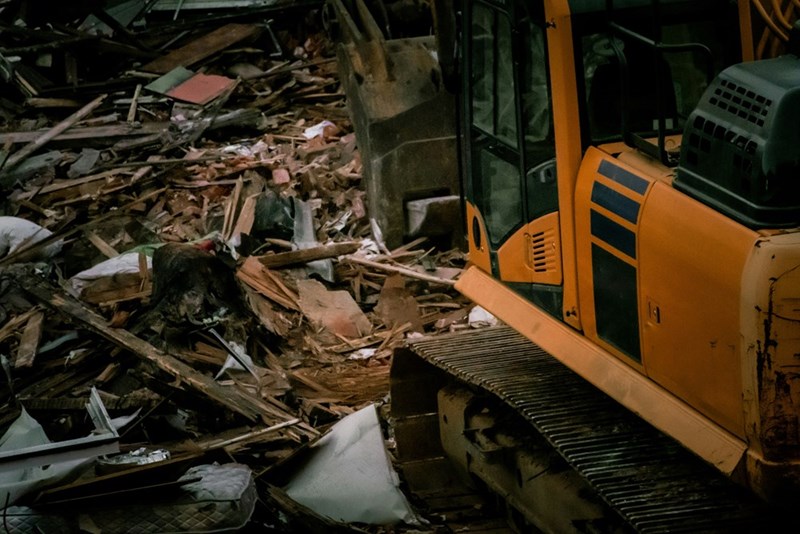 An excavator among the remains of a demolished building