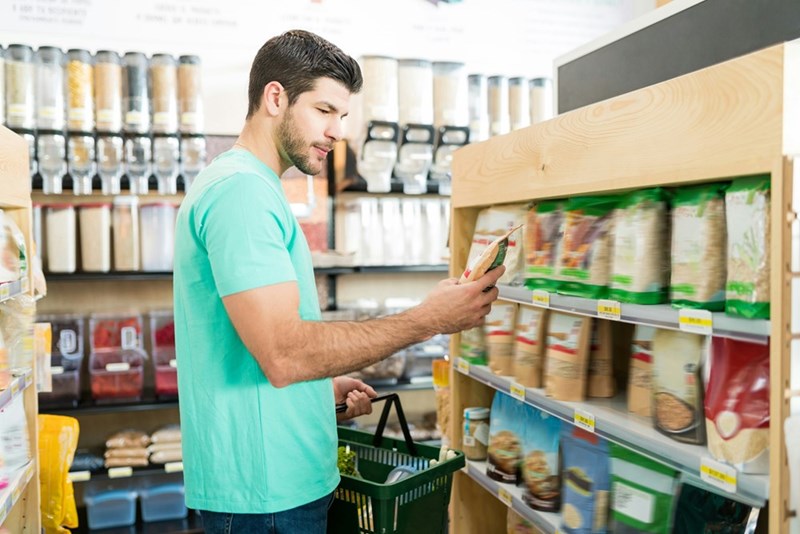Store employee checking a product while working in a store aisle.