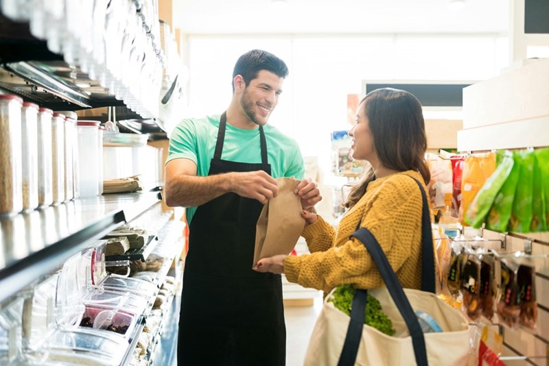Store worker helping a customer with her purchase inside the shop.