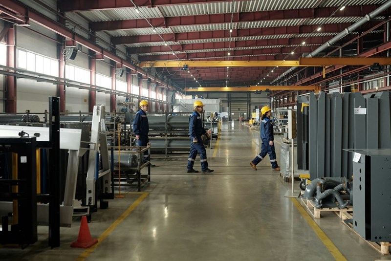 Employees walking through a metal distribution factory.