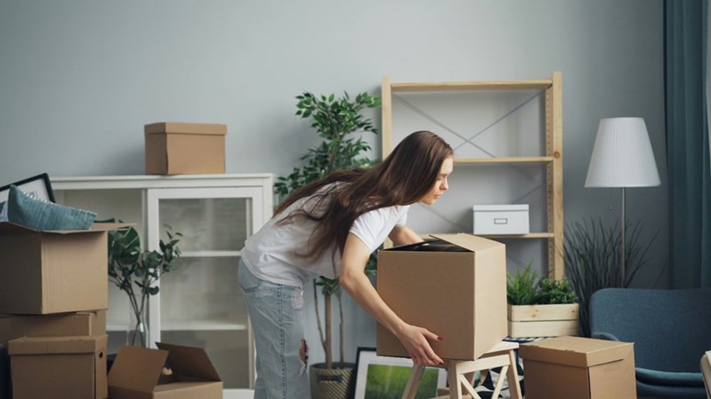 A woman moving boxes full of her things around. Representative only.