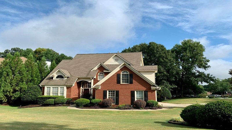 A big house seen from the outside with a green garden.