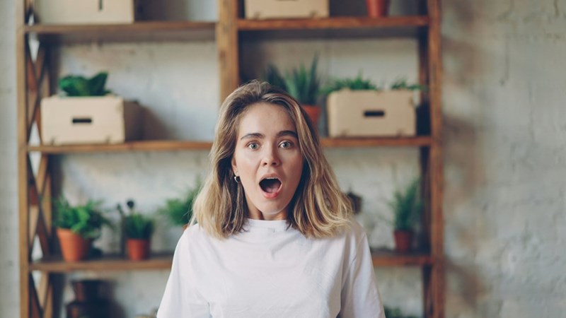 Young woman with surprised expression looking forward