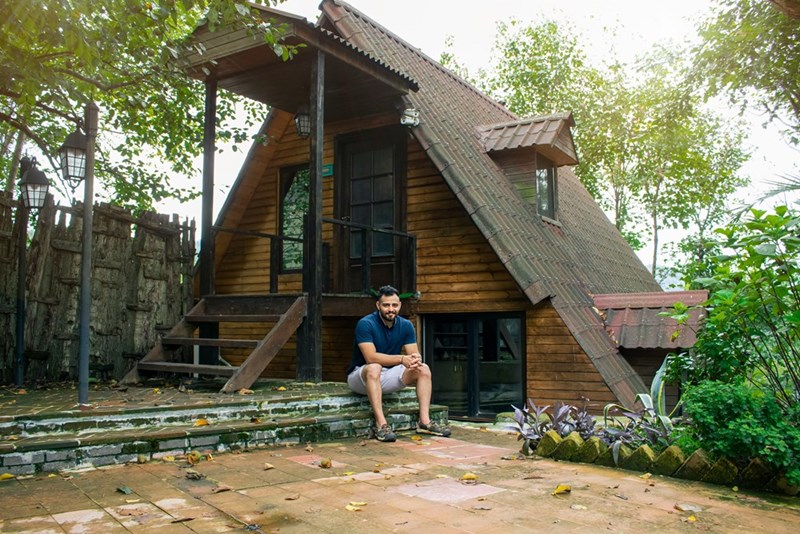 Man sitting on steps of a wooden a frame house