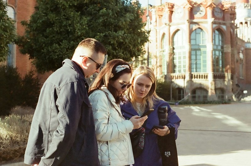 Parents stand with their college aged daughter on a campus outside