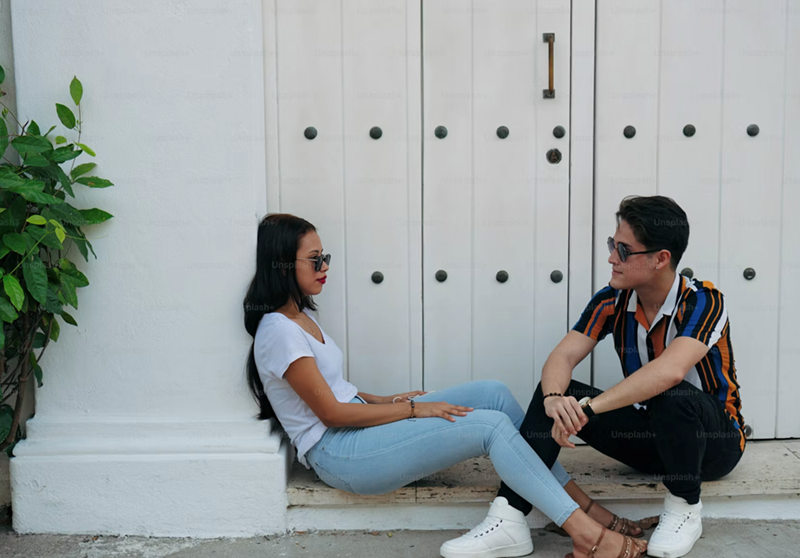 A couple sit on a stoop outside having an argument