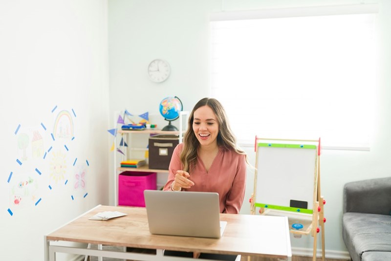 Teacher using her laptop to email her students parents